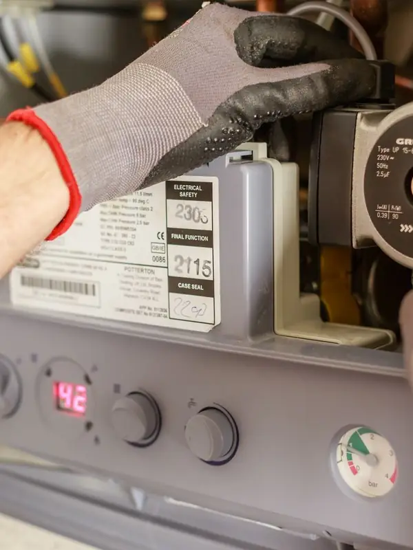 Heating engineer servicing a wall mounted boiler